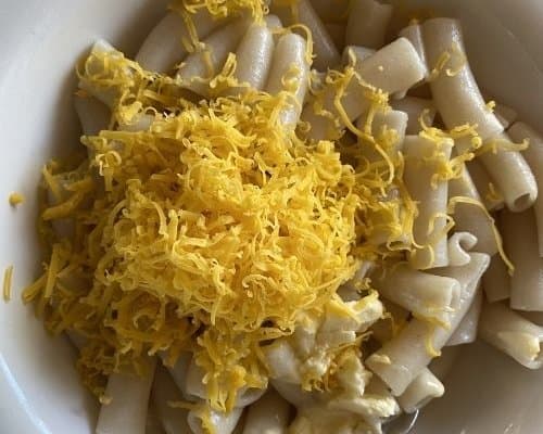 Pasta with grated cheese in white bowl