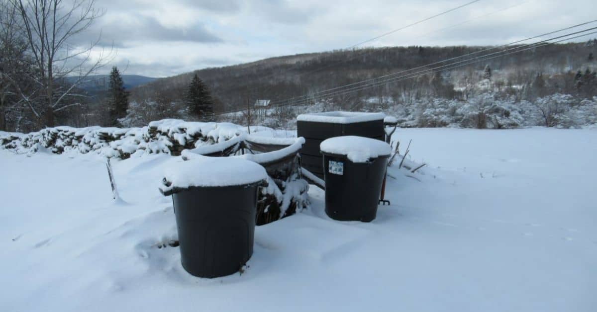 cloudy sky, mountain, snow, black compost barrels and bins
